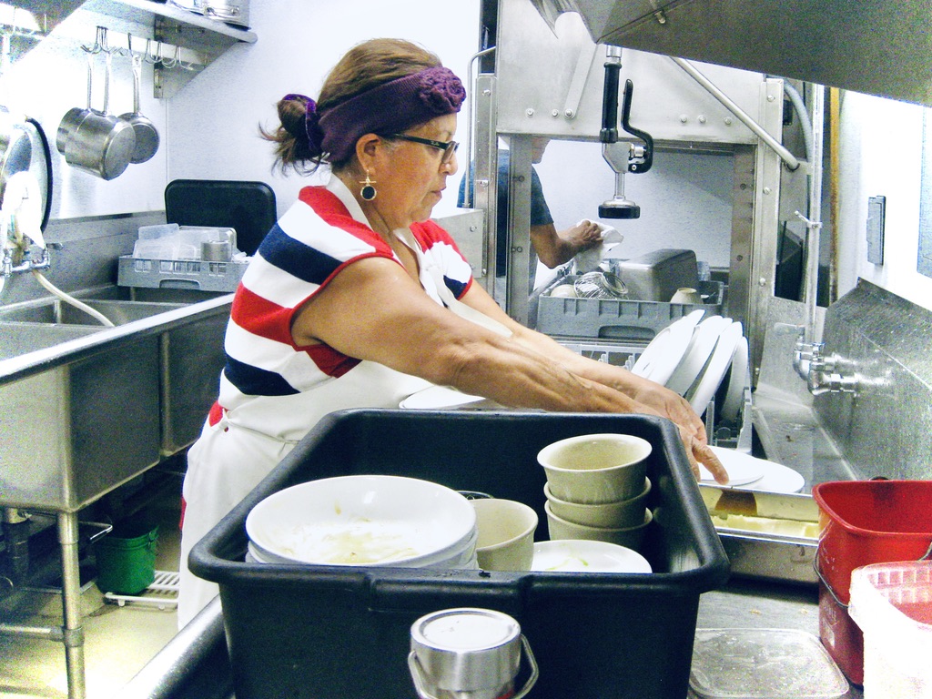 dishwasher placing dishes in kitchen